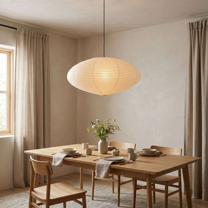 Warm washi paper pendant light above a wood dining table.