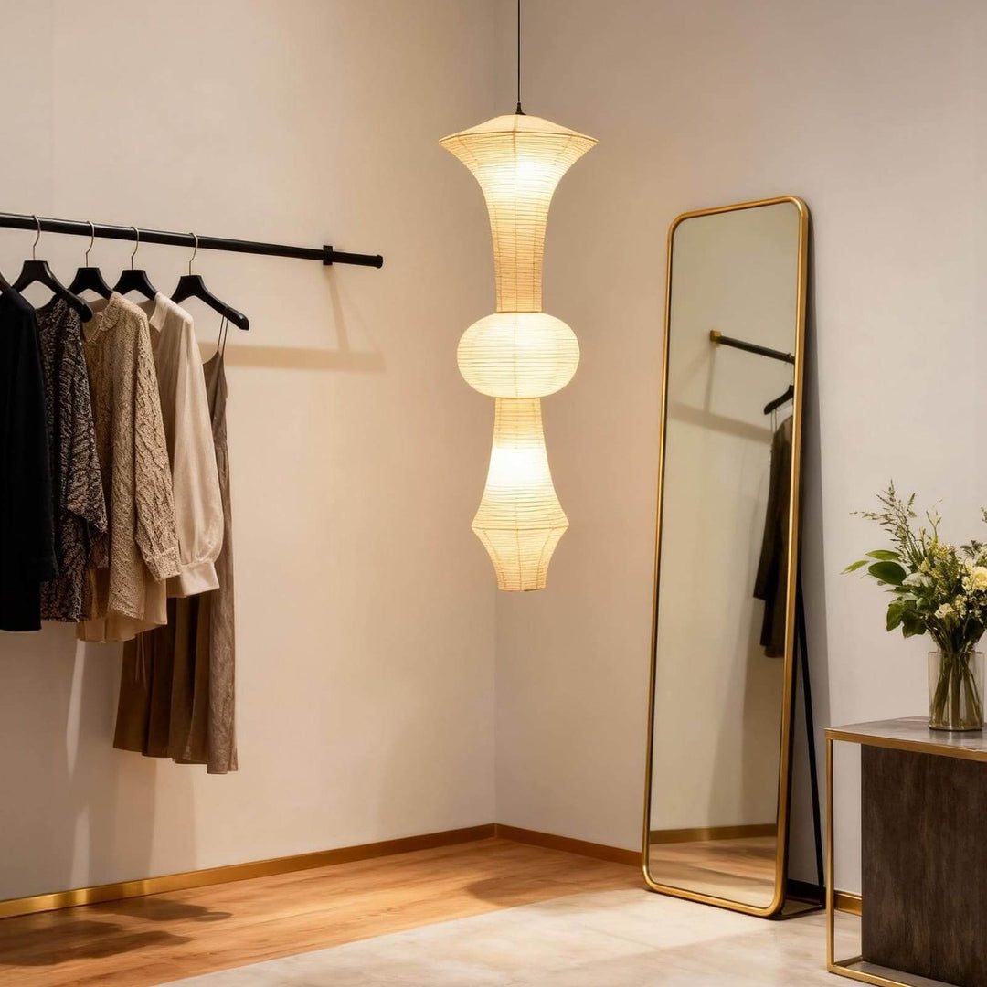Tall Washi paper pendant light hanging through a modern stairwell with dark stone steps and metal railings