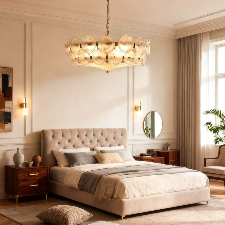 White and gold bedroom chandelier casting a warm glow above a modern bed