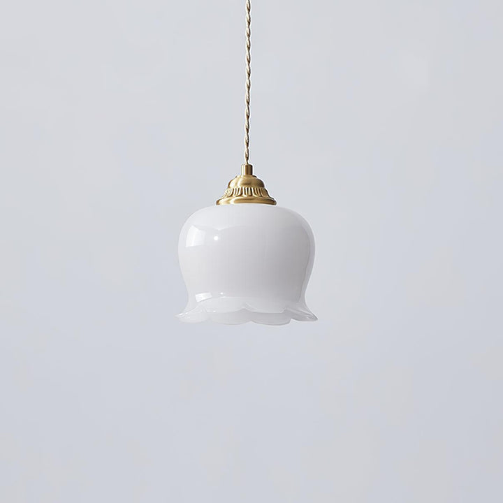 Brass and white flower pendant light with a scalloped resin shade and light-colored twisted cord