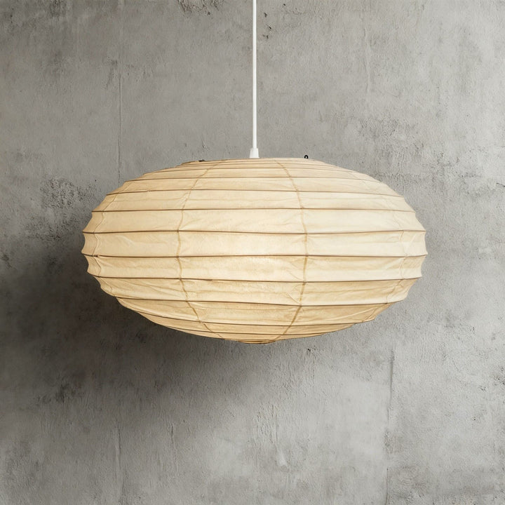 White cord washi paper pendant light shown close against a gray wall.