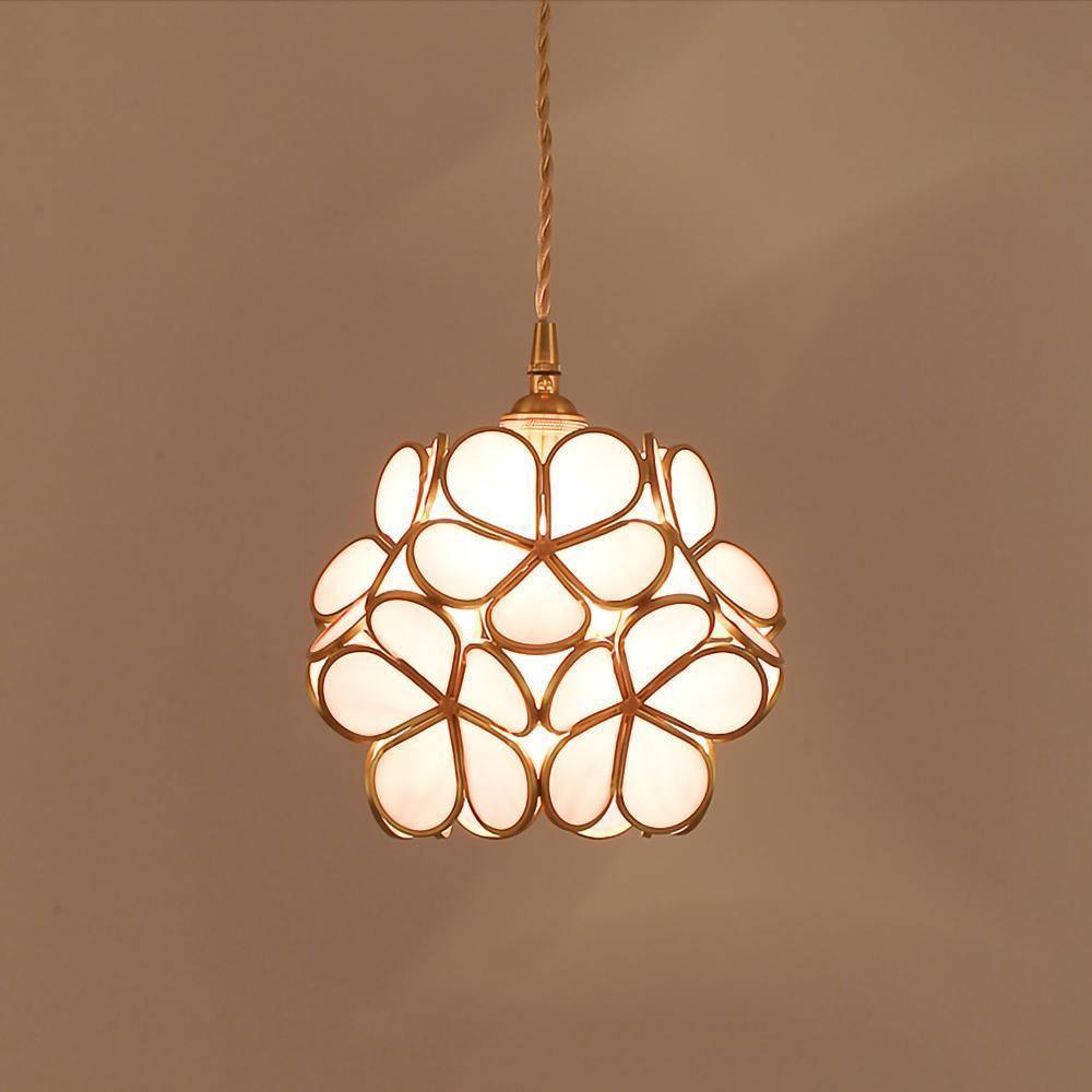 White glass petal pendant light with overlapping floral shades glowing warmly
