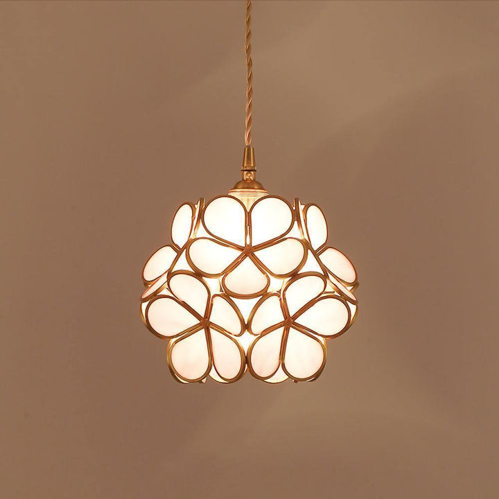 White glass petal pendant light with overlapping floral shades glowing warmly