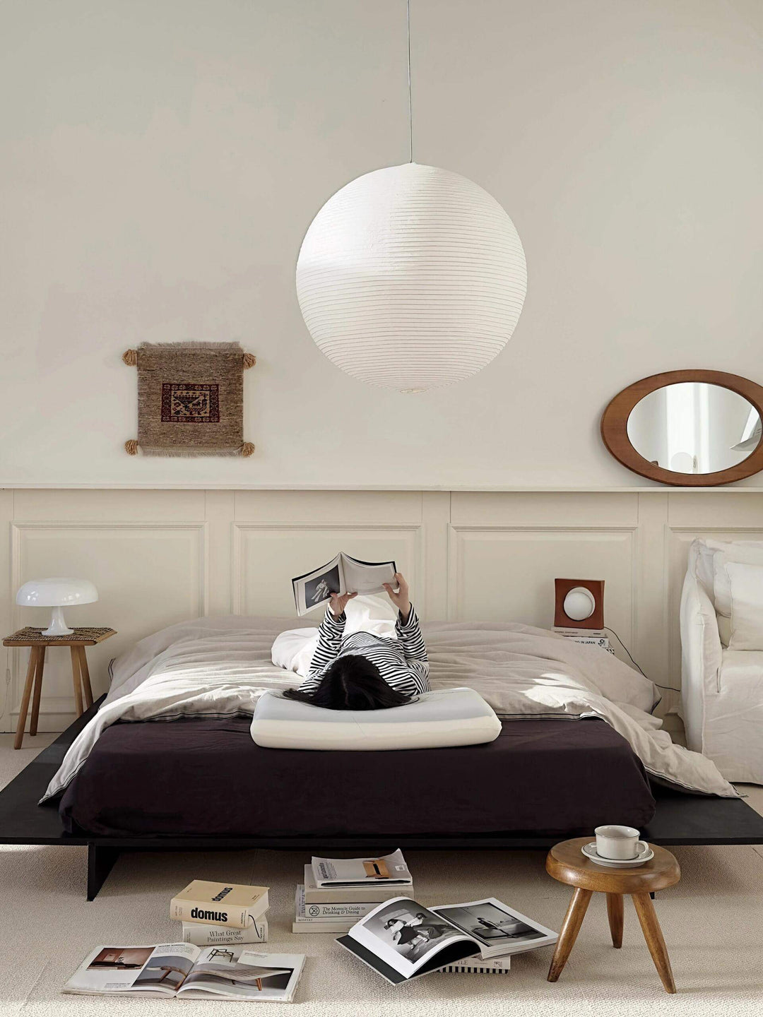 White round rice paper pendant light centered above a modern platform bed