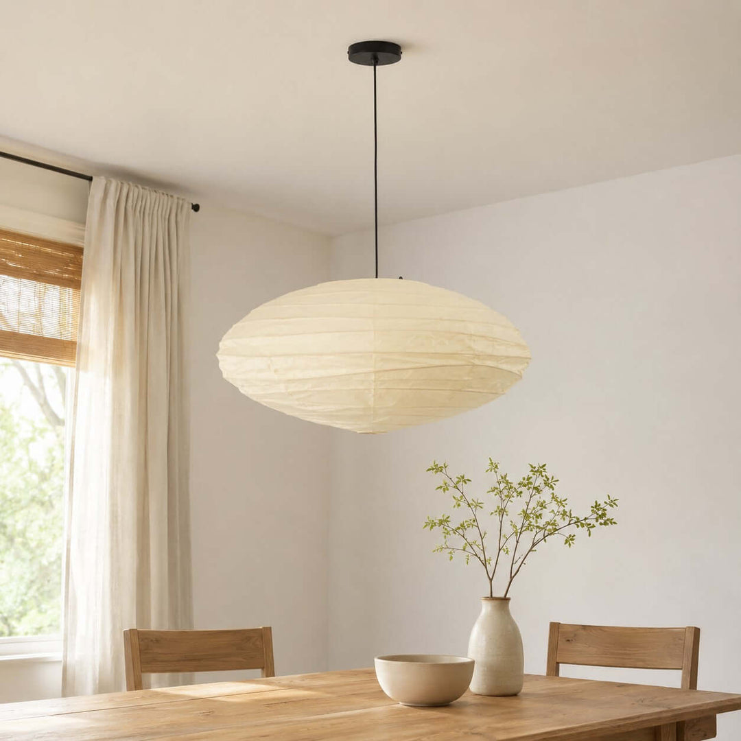 White washi paper pendant light shown close above a dining table.