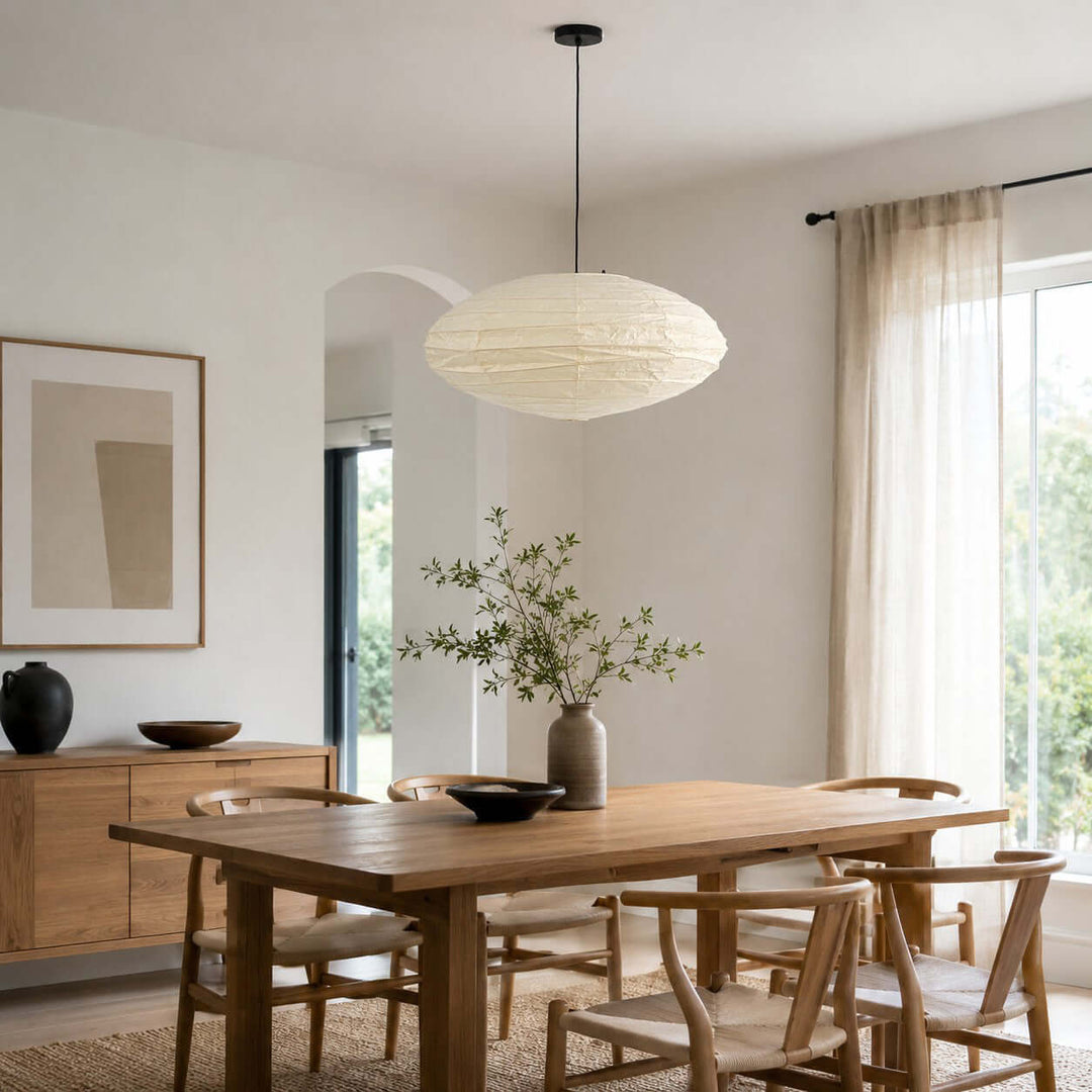 White washi paper pendant light above a wood dining table.