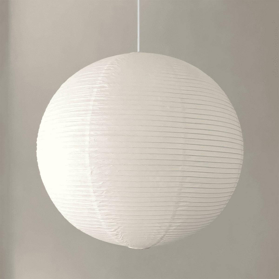 White round paper lantern pendant shown from the side with a white wire