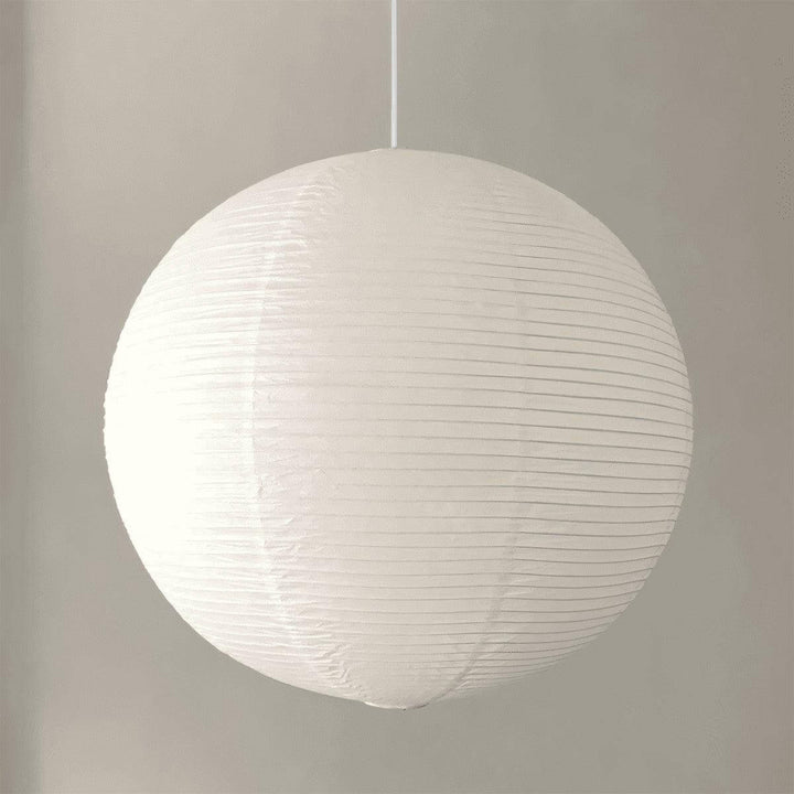 White round paper lantern pendant shown from the side with a white wire