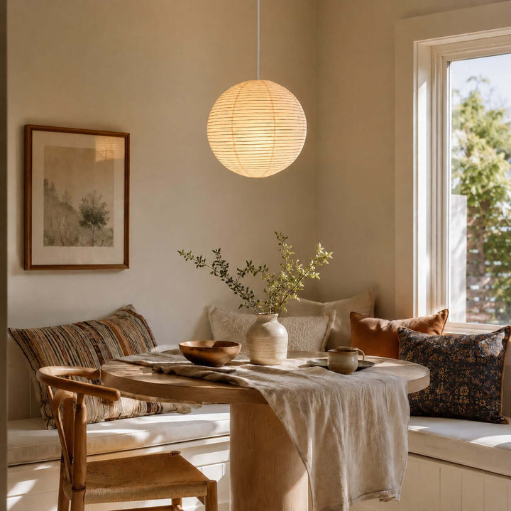 Round rice paper pendant with a white wire above a bright breakfast nook