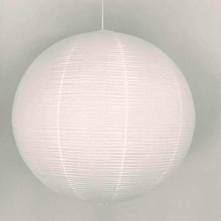 Close front view of a round rice paper pendant light with a white wire