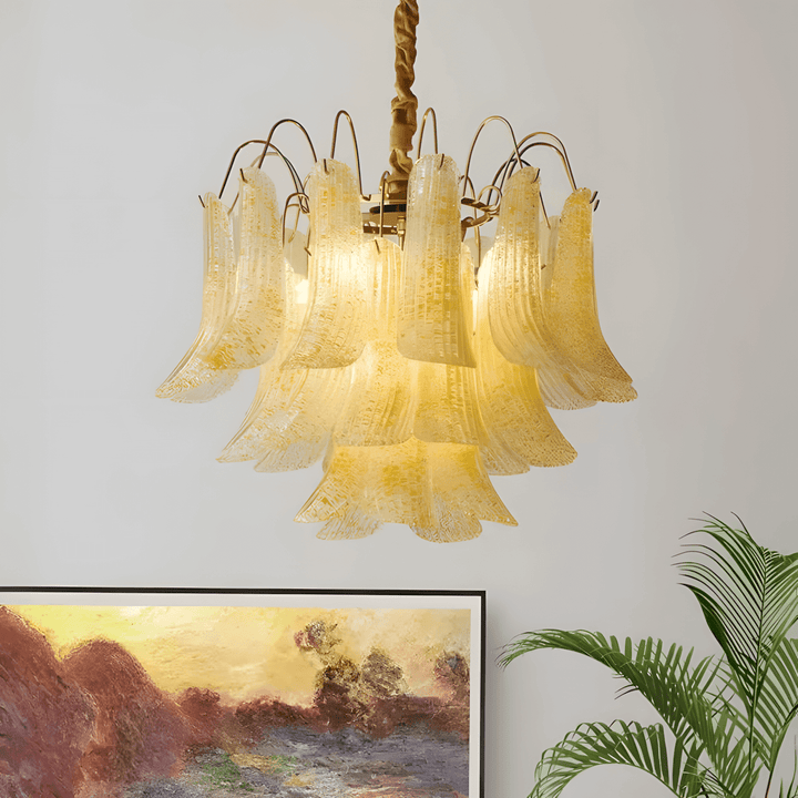 Yellow Murano glass chandelier casting a warm glow above framed wall art