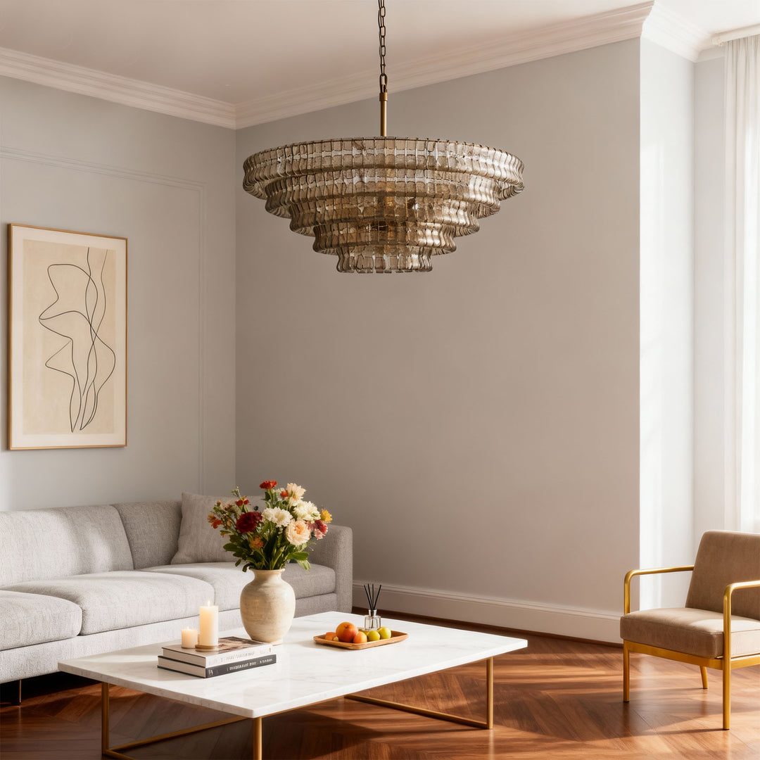 Smoky tiered glass chandelier hanging over a coffee table in a bright room with a gray sofa