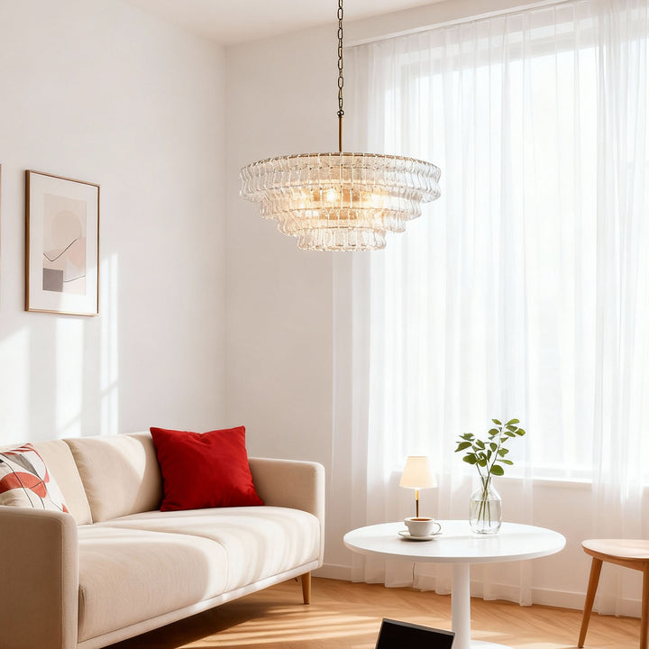 Clear glass chandelier over a sunny seating area with a cream sofa and round table