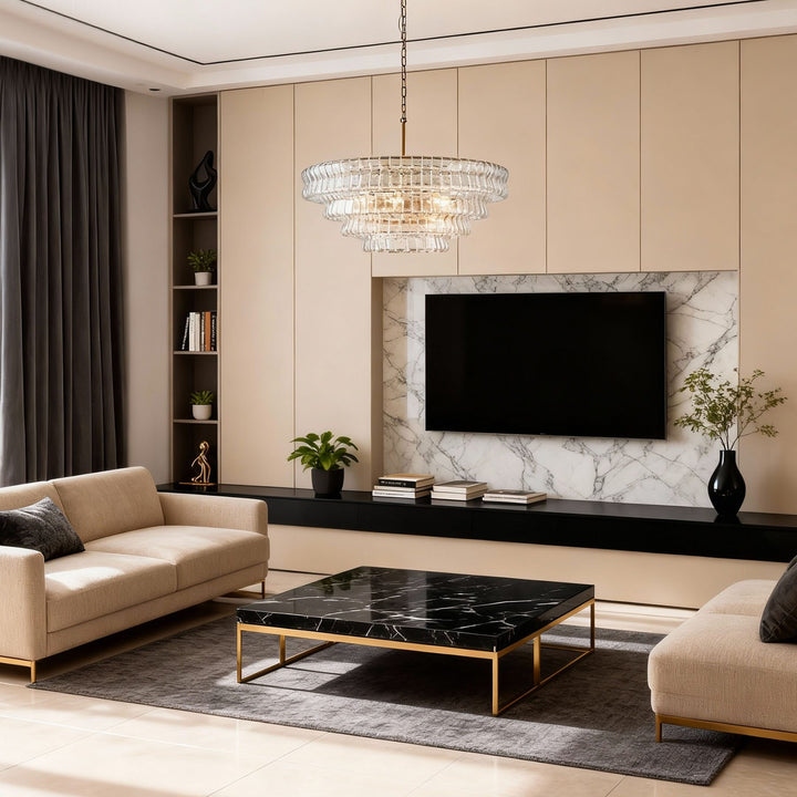 Clear tiered glass chandelier above a modern living room with sofa and TV wall