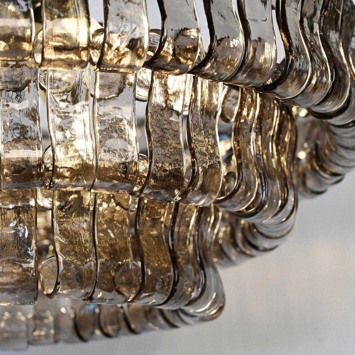 Close up of smoky wavy glass panels with warm light shining through the shade