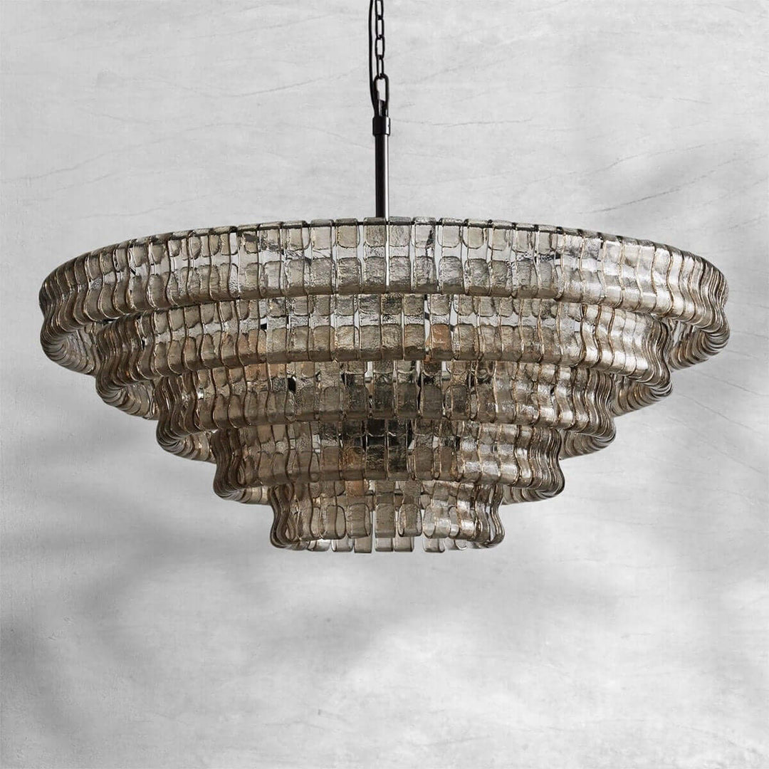 Smoky wide glass chandelier with a black chain and layered shade on a gray background