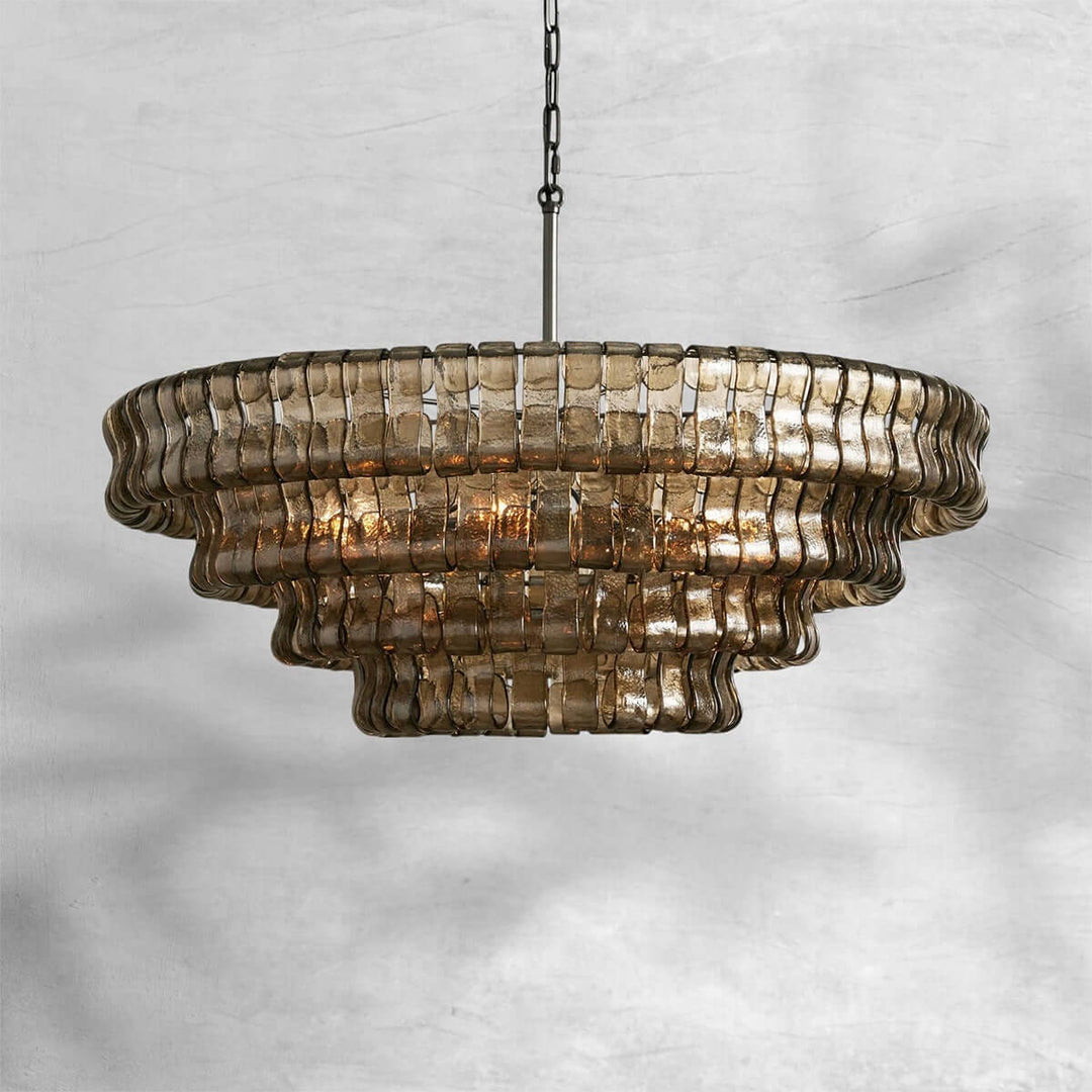 Smoky round glass chandelier with a black chain and warm bulbs on a gray background