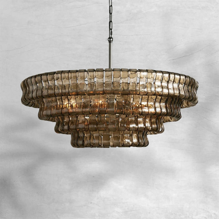 Smoky round glass chandelier with a black chain and warm bulbs on a gray background