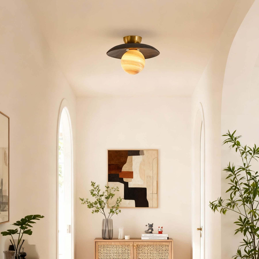 Brown Zolira ceiling light with amber art glass installed in a minimalist arched hallway