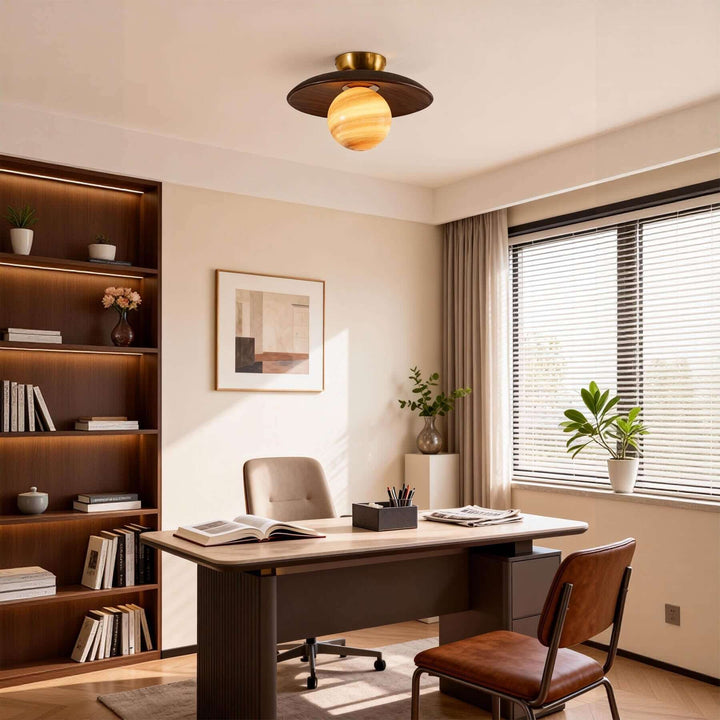 Brown Zolira ceiling lamp illuminating a warm home office with built-in bookshelves