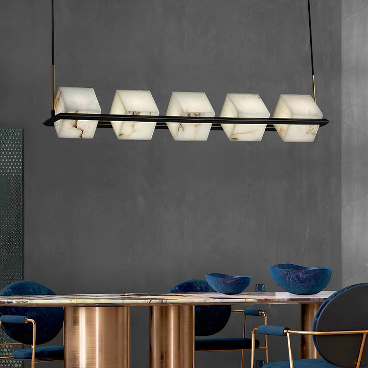Mid century modern alabaster square box chandelier above a stylish dining table with blue chairs.