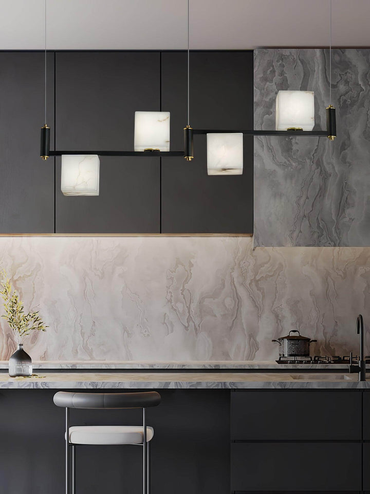 Mid-century modern alabaster square box chandelier above sleek kitchen island with dark cabinetry and marble backsplash.