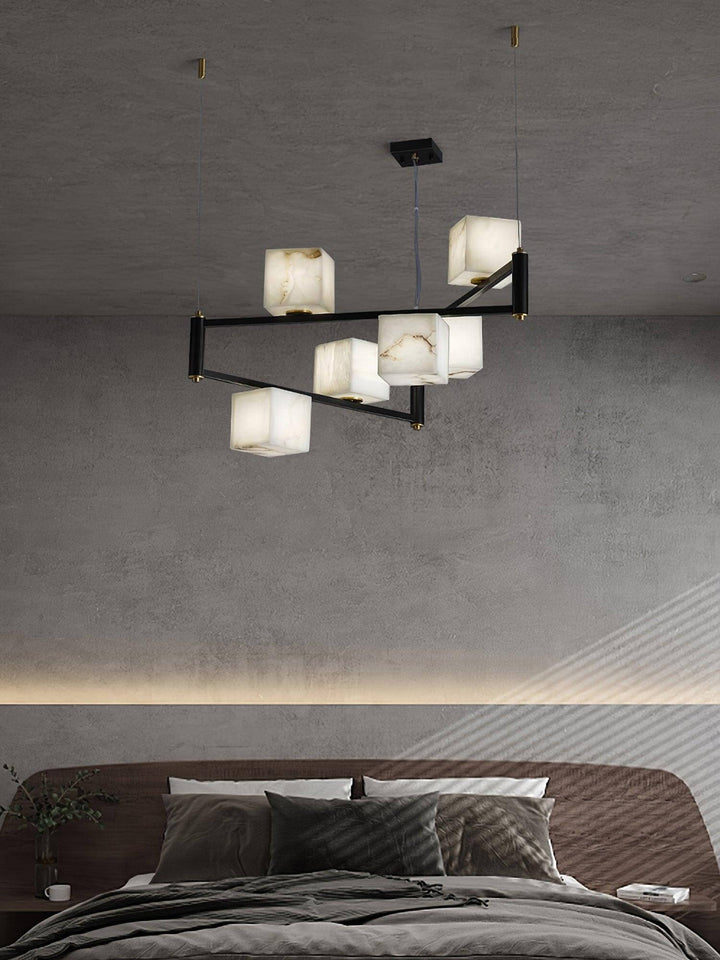 Mid century modern alabaster chandelier with five floating cubes above a contemporary bedroom.